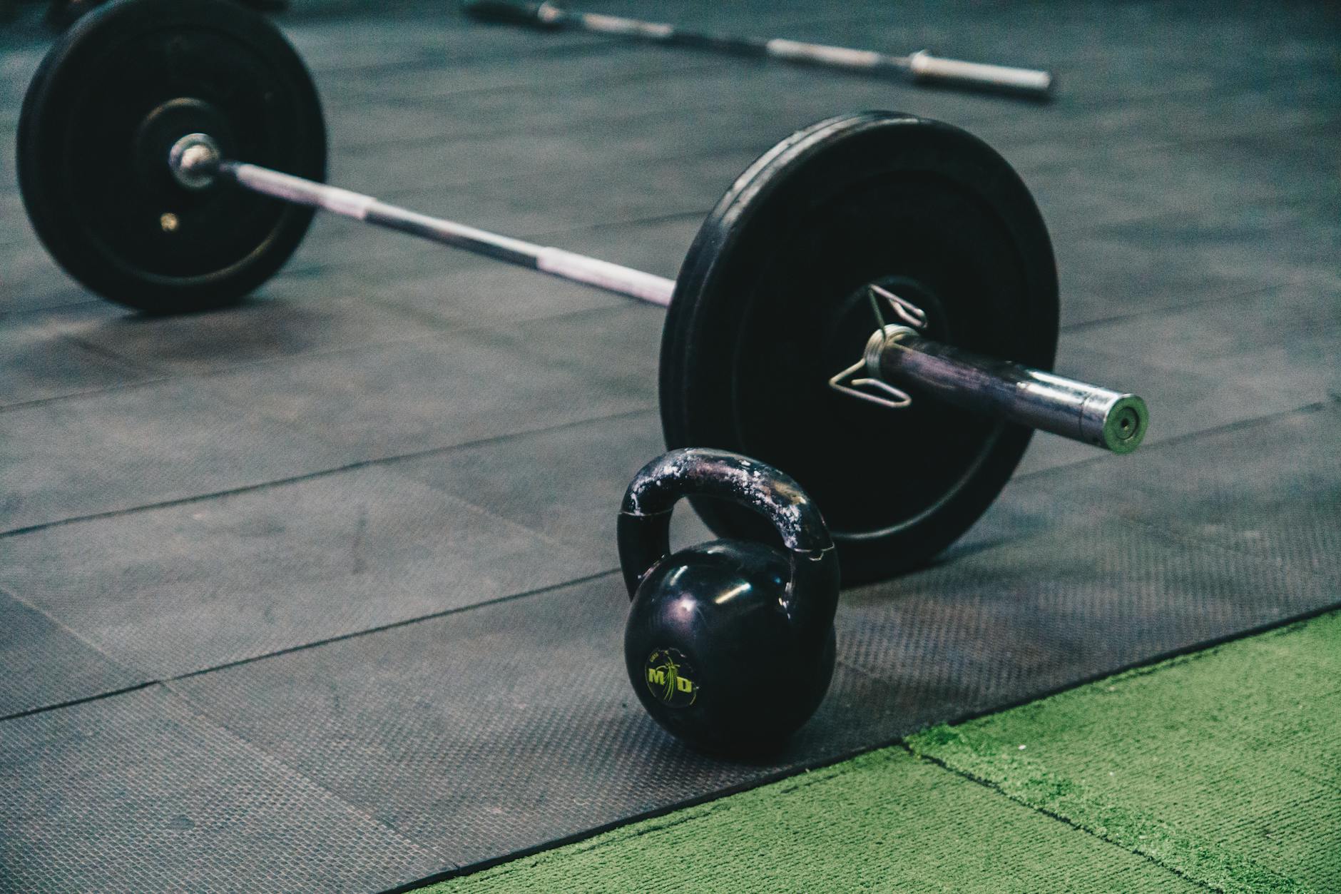 barbell and kettle bell on a black mat